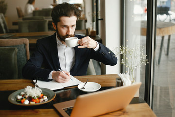 Handsome man in a black suit. Businessman working in a office