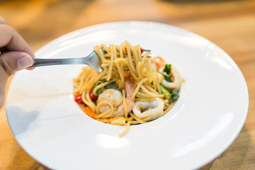 spaghetti seafood in whiite dish with tomato sauce for serve