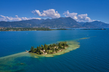 Unique view of the island of San Biagio. In the background is the Alps. Resort place on Lake Garda north of Italy.