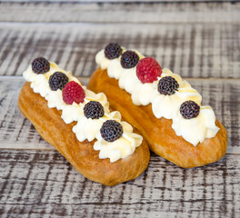eclairs with vanilla cream cheese decorated with fressh berries