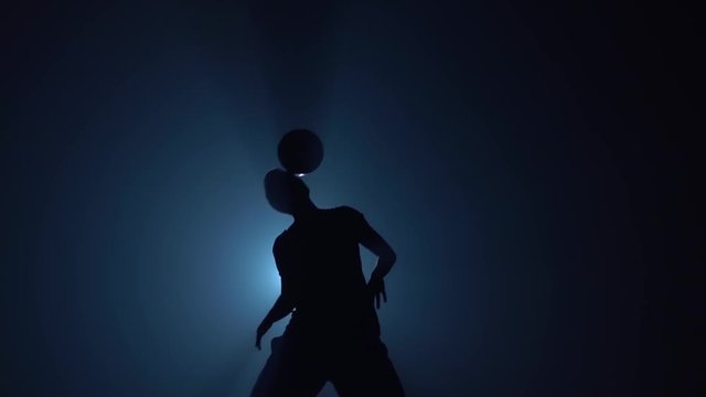 Football freestyle. Slow motion, soccer player making tricks with ball on head.