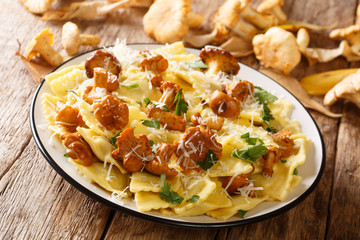 Homemade ravioli with fried chanterelle mushrooms and parmesan cheese closeup on a plate. horizontal