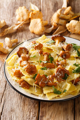 Pasta ravioli with fried chanterelles and parmesan cheese close-up on a plate. vertical