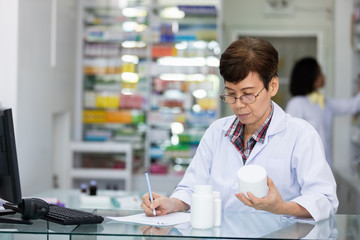 young asian women pharmacist check drugs and packages in pharmacy store