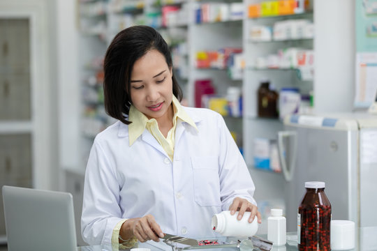 young asian women pharmacist check drugs and packages in pharmacy store