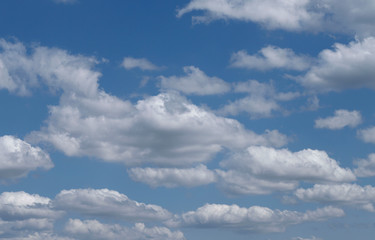Blue sky background with white clouds. Cropped shot, horizontal, free space. Concept of natural beauty.