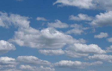 Obraz premium Blue sky background with white clouds. Cropped shot, horizontal, free space. Concept of natural beauty.