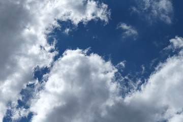 Obraz premium Blue sky background with white clouds. Cropped shot, horizontal, free space. Concept of natural beauty.