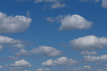 Naklejka na ściany i meble Blue sky background with white clouds. Cropped shot, horizontal, free space. Concept of natural beauty.