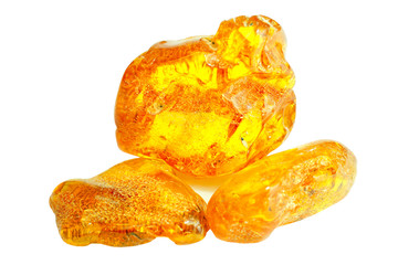 Amber. Three pieces of transparent yellow amber on a white background. Sun stone. Natural mineral fossilized ancient resin. Material for jewelry products. Yellow colored stone
