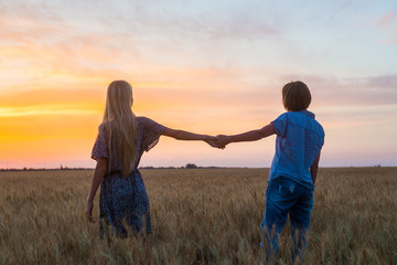 Mom of middle age and daughter teenager in a field at sunset. Relationship, understanding between...