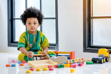 African young boy has fun with playing various type of toys.