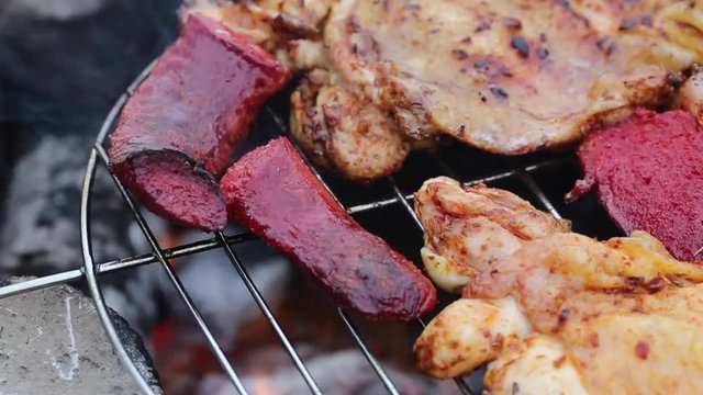 sausage and chicken cooking on a barbecue