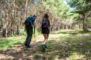 Naklejka premium young man and woman walk the mountain to the top