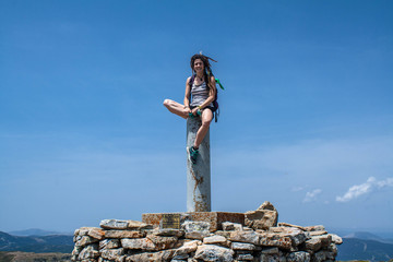 young girl sitting on the peak of the mountain