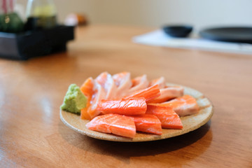 Serving crab sticks and salmon with wasabi selective focus