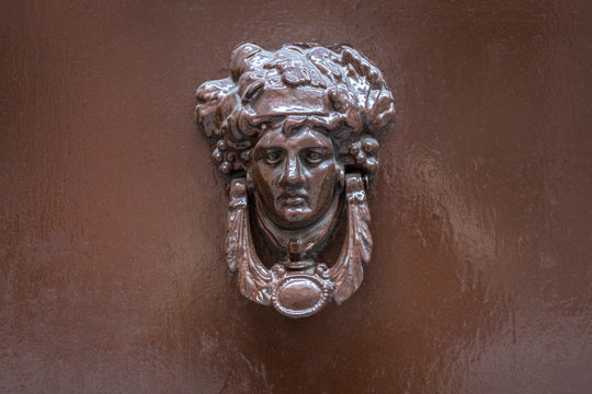 Una aldaba de bronce en un port&oacute;n antiguo