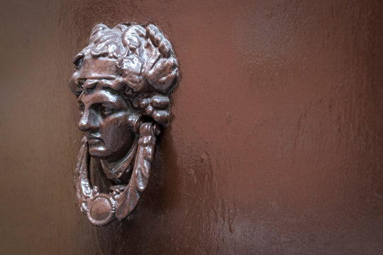 Una aldaba de bronce en un port&oacute;n antiguo