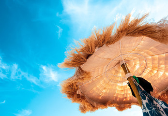 View from below of beautiful thatched umbrellas on the beach.
