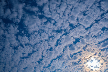 Obraz premium The sun's ray passes through the cirrus clouds in the blue sky.