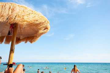 Beach beautiful thatched umbrellas and turquoise sea.