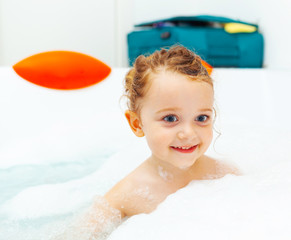 Little girl takes a bath in a hydromassage bathtub.