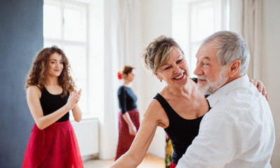 Group of senior people in dancing class with dance teacher.