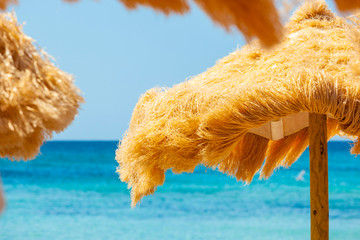 Beach beautiful thatched umbrellas and turquoise sea.