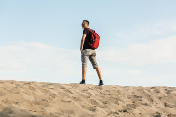 Backpacker tourist standing desert trail looking beautiful mountains landscape view, hiking traveling