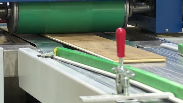 Machine for gluing laminated floor panels. Gluing laminate to a wooden base under pressure and heat.