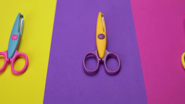 Set of a variety of wavy blade scissors for scrap booking on colorful paper moves from right to left. Abstract minimal background with space for text.