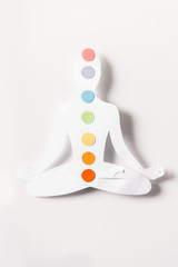 top view of paper figure in form of person with chakras in lotus pose on white