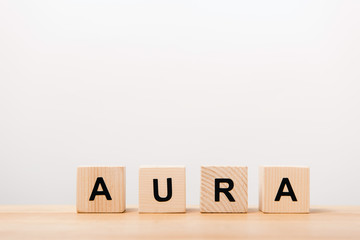 word aura lettering on wooden blocks on white