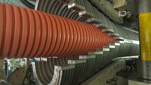 Factory production plastic corrugated pipes for water supply, sewage, plumbing. Process of making plastic pipes on machine tool with use of water and air pressure. Manufacturing of tubes to factory.