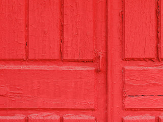 Fragment of distressed red rustic wooden door painted in red orange peeled dye for design background and texture