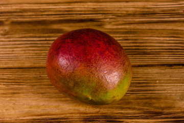 Whole red mango fruit on a wooden table