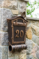 brown mailbox on the fence in front of the house
