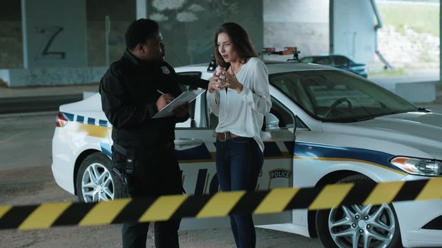 Close up policeman interrogates a woman in an incident arrest criminal enforcement burglar man officer black bad robbery business busted illegal slow motion