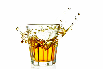 whiskey in a glass splash isolated on white background with reflection