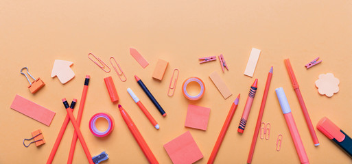 Flat lay of office, school stationery on orange color background