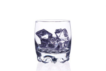 A glass of whiskey with ice cubes on a white background.