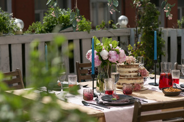 tiered wedding cake with flowers on terrace