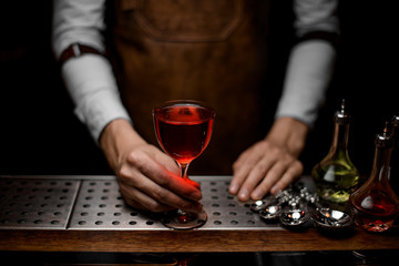 Close-up of bartender with glass of cocktail on counter