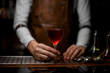 Close-up of bartender with glass with cocktail on counter