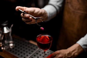 Bartender dropping flower in an alcohol cocktail