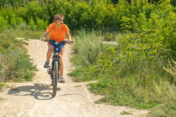Teenager riding a bike in the forest