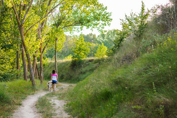 Middle-aged woman walking with her dog on a mountain path