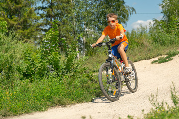 Naklejka premium Teenager riding a bike in the forest