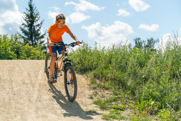Obraz premium A boy on a mountain bike drives off a hill