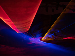 Rote, blaue und gelbe Lichttunnel vor schwarzem Hintergrund